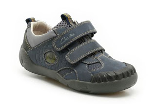 A single children's navy blue trainer from Clarks Shoes with grey accents, two Velcro straps, and a rugged black sole. The shoe features visible stitching and a small logo on one strap—ideal for any Shoes Review.