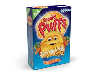 A cereal box labelled "Spooky Puffs" features a fluffy yellow monster with big eyes and two green creatures on each side. The blue box showcases Spooky Cereal pieces at the bottom for a fun breakfast treat.