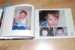 An open Snapfish photo album shows pictures of a young boy with light brown hair, smiling and pulling faces, on a wooden floor. Four photos are visible: one on the left page and three on the right page.