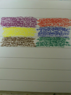 Crayon scribbles of six colours—purple, red, yellow, blue, brown, and green—are drawn in rectangular blocks on lined paper. The arrangement in two rows of three showcases a playful use of Stabilo writing products.