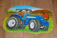 A colourful jigsaw puzzle from the Puzzles Website shows a blue tractor driven by a person, with a red horse and sheep in a grassy farm scene. The Jigsaw Puzzles pieces are arranged on a wooden floor.