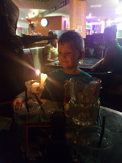A boy sits at a table with drinks, enjoying his time at Frankie & Benny’s.