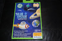 A LeapFrog Tag Reading System Solar System Adventure Pack box features cartoon images of a rocket, planets, and Earth. The mainly blue packaging includes educational information for children aged 4-8 years.