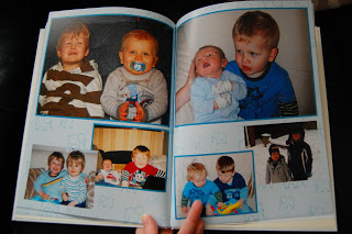 A Crewe Photo Book open to two pages, displaying several pictures of young children. The children are smiling, playing, and sitting together with toys, and one image shows two kids outdoors in winter clothing.