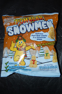 A packet of Pom-Bear Snowmen snacks with an orange winter-themed design, featuring a bear in a reindeer costume and snowman-shaped snacks—perfect for fans of Pom-Bears and festive Pigs in Blankets flavours.