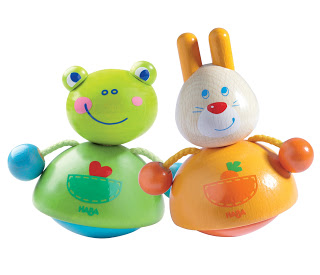 Two colourful wooden wobble toys—a green frog with blue hands and a white and orange bunny—both feature smiling faces and playful designs, making them perfect Christmas gift ideas for younger children.