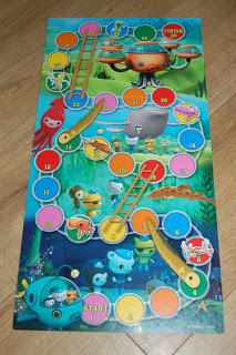 A colourful Octonauts Sea Eels and Ladders game board with numbered spaces, ladders, and show characters, set on an underwater background filled with sea creatures and plants. The path begins at the bottom and ends at the top right.