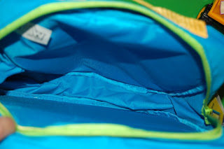 An open, empty blue WOW Pack Wanderer rucksack with a light green zip, showing its spacious interior and fabric lining.
