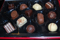 A box of assorted Butlers Chocolate, each piece with a unique shape, colour, and decoration, arranged neatly in a black plastic tray—a perfect chocolate collection for gifting.