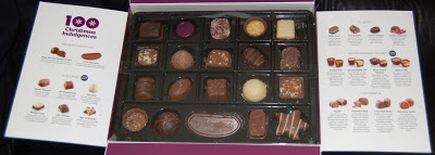 An open box of Thornton’s Christmas assorted chocolates with an informational guide on each side, showing descriptions and images of the festive treats inside. Some chocolates are missing from the box.