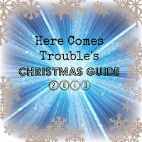 Blue and white burst background with gold snowflakes around the edges. Text in the centre reads: "Here Comes Trouble’s CHRISTMAS GUIDE 2013"—featuring ELC gifts and Sweet Music inspiration.