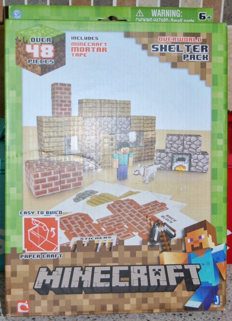 Box for a Minecraft Shelter Pack Papercraft set, featuring a paper shelter, fireplace, crafting table, and wolf. Includes a blocky Minecraft character in the corner and easy assembly instructions.