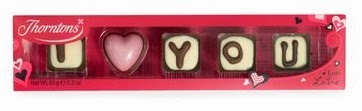 A box of chocolates spells out "I ♥ YOU" with white and pink heart-shaped treats in a red, heart-decorated package—one of Thornton’s Valentine’s Day gifts sure to melt their heart.