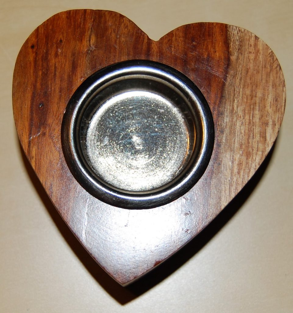A metal bowl is set into a heart-shaped wooden base, photographed from above on a beige surface—perfect for unique Valentine’s Day gifts from Wilko.