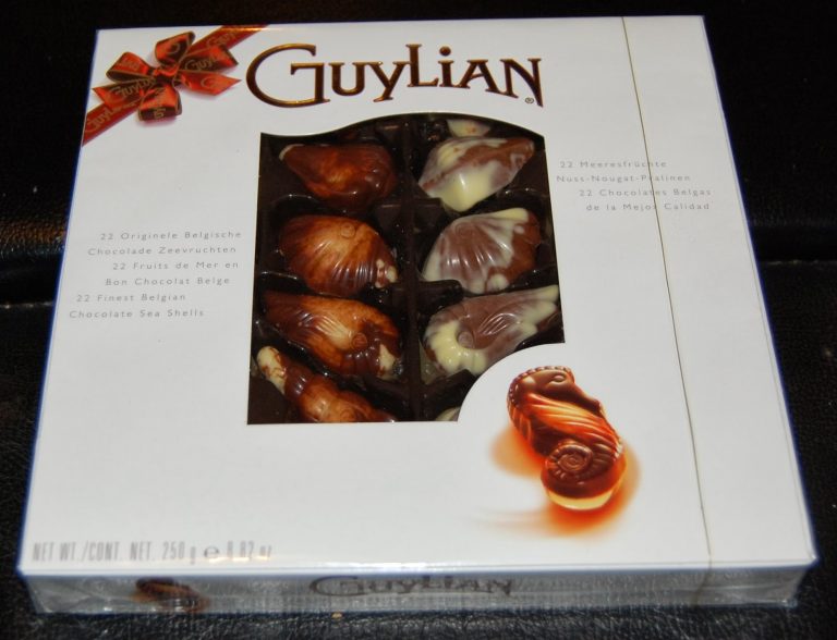A box of Guylian Belgian chocolates featuring 22 chocolate sea shells in assorted milk, white, and dark chocolate, visible through a window on the front of the white packaging—a perfect gift for Mother’s Day.