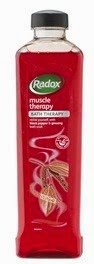 A tall, rectangular bottle of Radox Muscle Therapy Bath Soak with a black cap. The red label features the Radox logo and images of spices, making it perfect for muscle relaxation—an ideal choice for Father’s Day gift ideas.