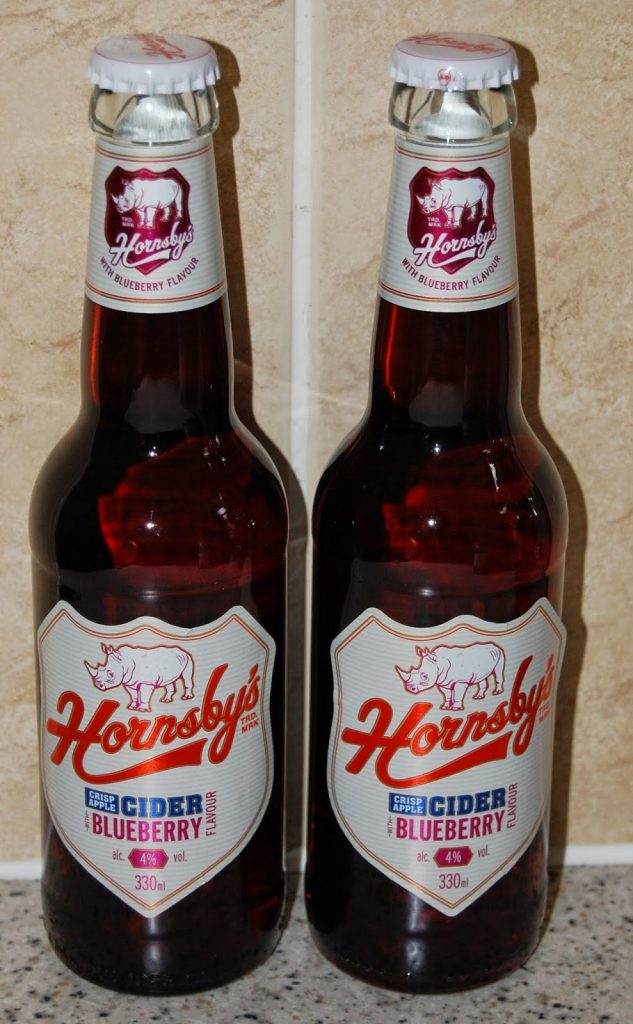Two bottles of Hornsby’s Blueberry Cider stand side by side on a speckled worktop, labels displaying a rhinoceros and 4% alcohol content—perfect for pairing with treats from your latest Degustabox snack box review.