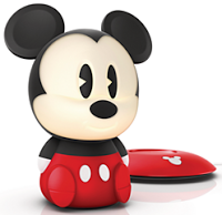 A small, stylised Mickey Mouse nightlight with a round head, large ears, red shorts, and white gloves stands next to a red, Mickey Mouse-themed light switch—perfect for adding charm to a child's bedroom or decorated room.