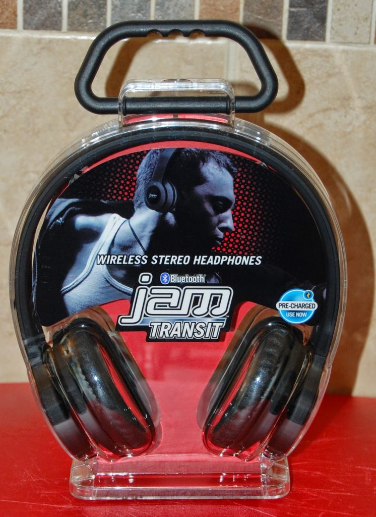 Wireless stereo headphones in clear packaging labelled “jam TRANSIT” and "Bluetooth." Perfect for music lovers, the package features a black-and-white photo of a person wearing headphones and mentions "Pre-Charged" with "Use Now.