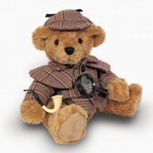A cuddly teddy bear dressed as a detective, wearing a brown checked hat and coat, sits against a plain white background, holding a magnifying glass and a pipe.