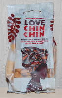 A small packet of Love Chin Chin Nigerian snacks, often featured in subscription box services such as Degustabox review, with a stylised woman in a patterned headwrap, red decorative leaves, and bold red text on the packaging.
