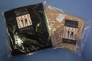 Two packs of ENVYSIBLE Shapewear, one black and one beige, each in clear plastic packaging with labels showing women modelling the shapewear on a blue surface.