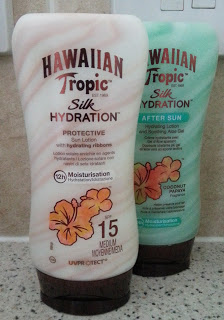 Two bottles of Hawaiian Tropic Silk Hydration lotion—one SPF 15 suncream and one after-sun lotion—sit on a bathroom counter. Shop both at Chemist Direct for summer-ready skin.