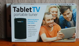 A TabletTV portable tuner product box shows three smiling people enjoying a tablet. The packaging highlights features like watching and recording TV on your tablet, no contract required—perfect for anyone seeking a hands-on review experience.