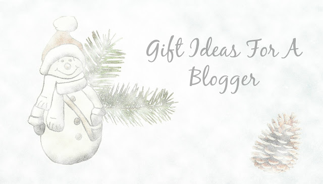 Watercolour illustration of a smiling snowman with a scarf and hat, next to pine branches and a pine cone. The text reads: "Gifts For A Blogger" in a stylish script font.