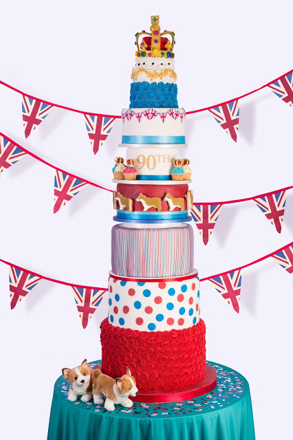 A multi-tiered cream cake adorned with flags and luscious strawberries, fit for a queen.