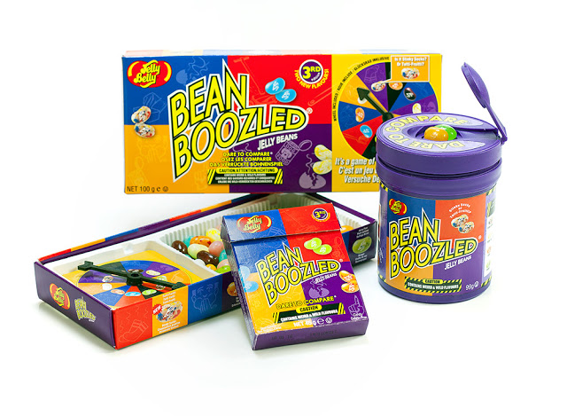 BeanBoozled jelly bean game products by Jelly Belly, including boxed sets, a purple tub, and colourful jelly beans, all with a spinner to win fun flavour challenges.