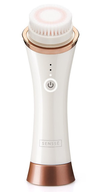 A white and rose gold Anti-Ageing Facial Cleansing Brush with a round exfoliator bristle head, power button, and LED indicator lights. The brand name "SENSSE" is displayed near the base. Perfect for a glowing complexion—ideal for any skincare giveaway!.