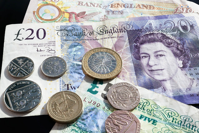 A close-up of British currency, showing £20 and £10 banknotes and various coins—perfect if you're running low on cash and searching for money-saving tips. The £20 note features a portrait of Queen Elizabeth II.