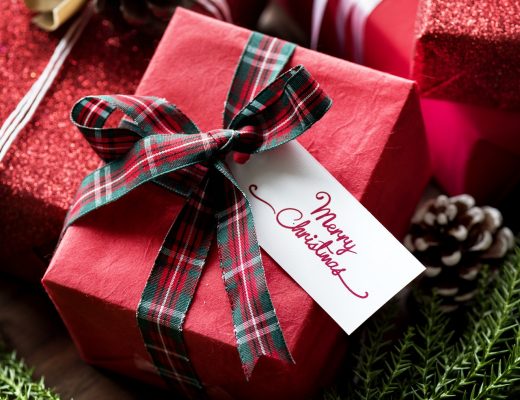A pile of presents wrapped in red gift wrap and tartan bows