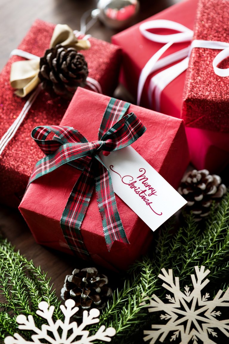 A pile of presents wrapped in red gift wrap and tartan bows