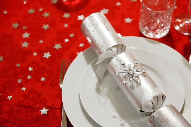 A Silver Christmas cracker placed upon a white dinner plate