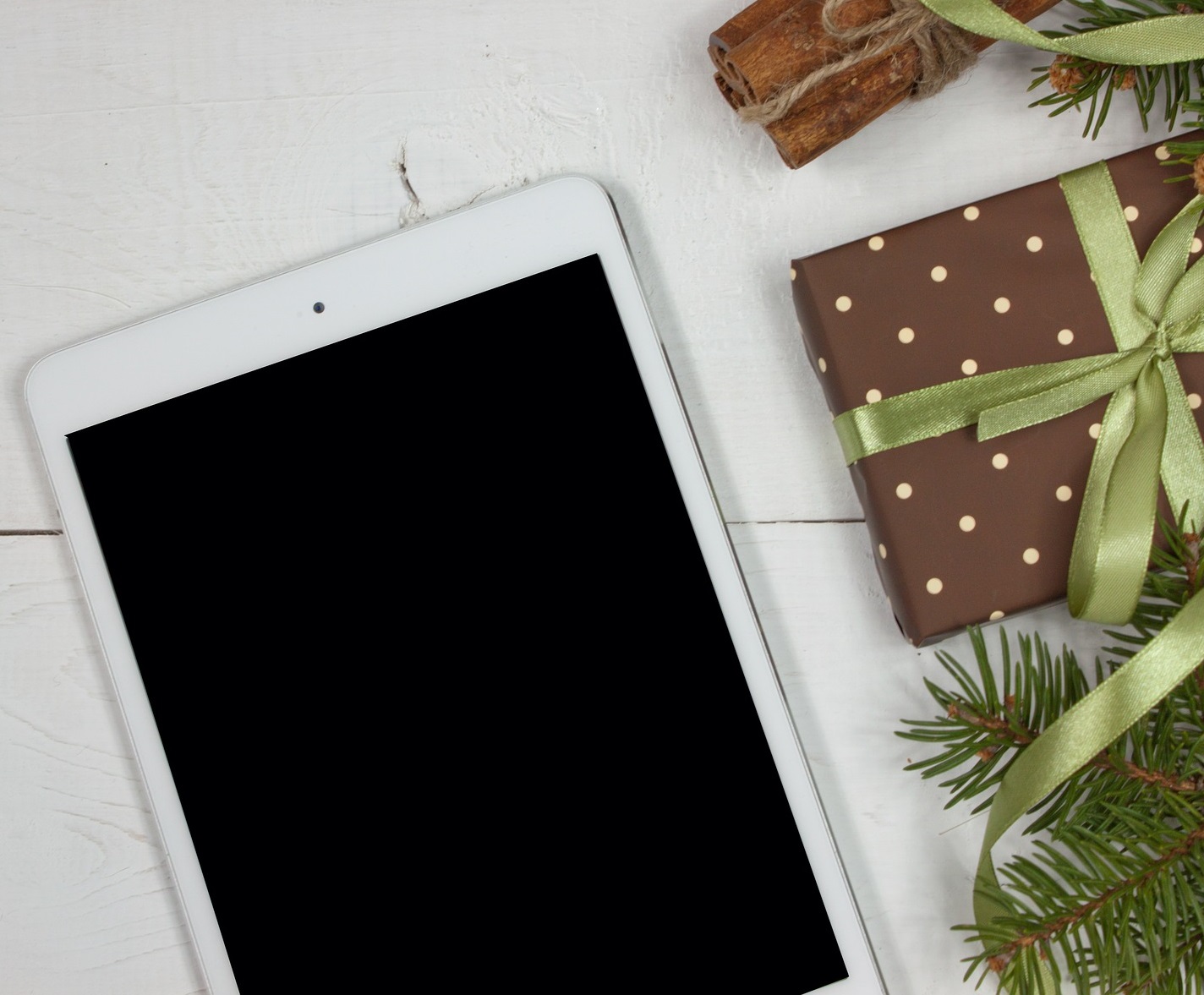 ipad tablet on a white background with brown Christmas present next to it