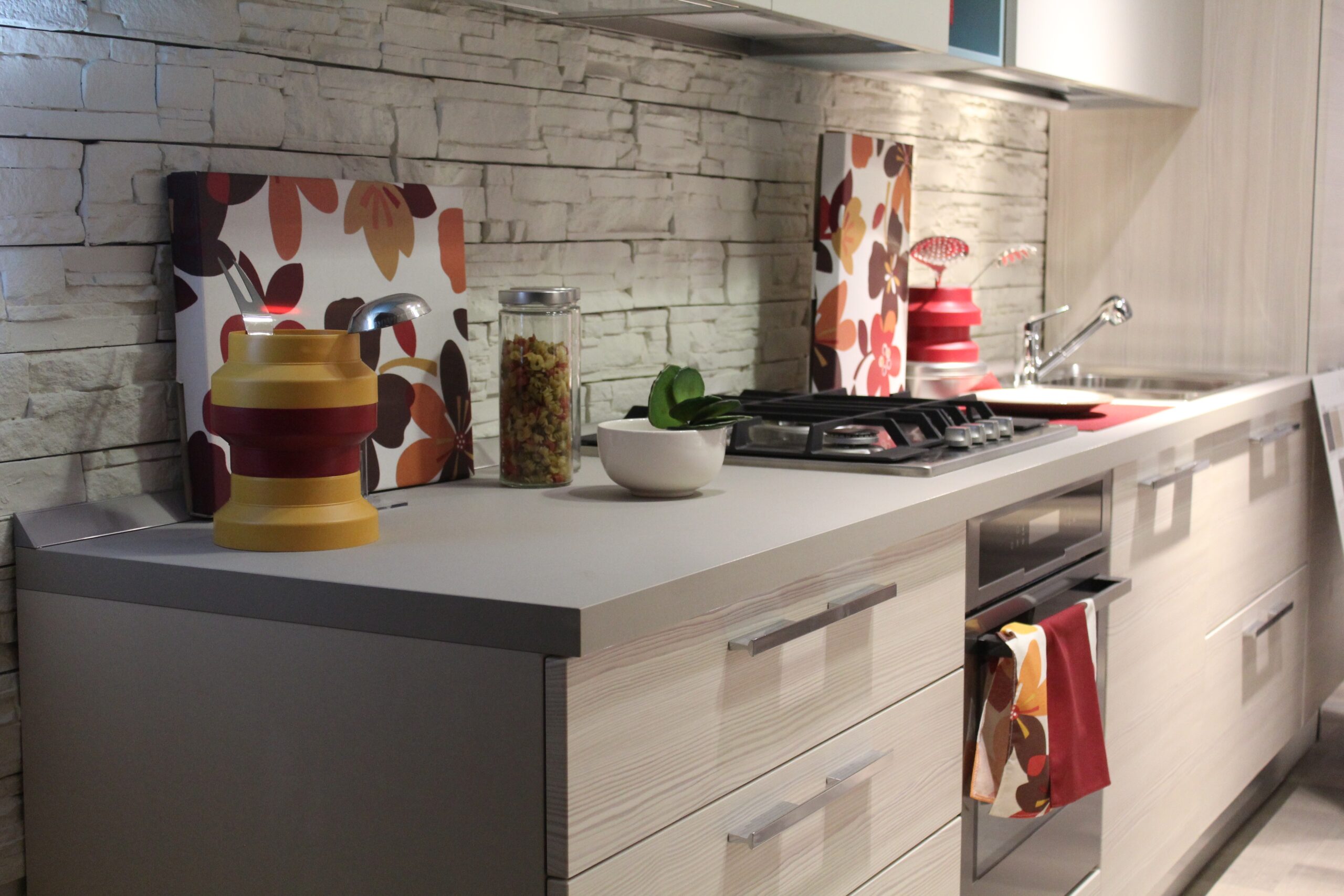 A modern white kitchen unit with a built in oven and hob