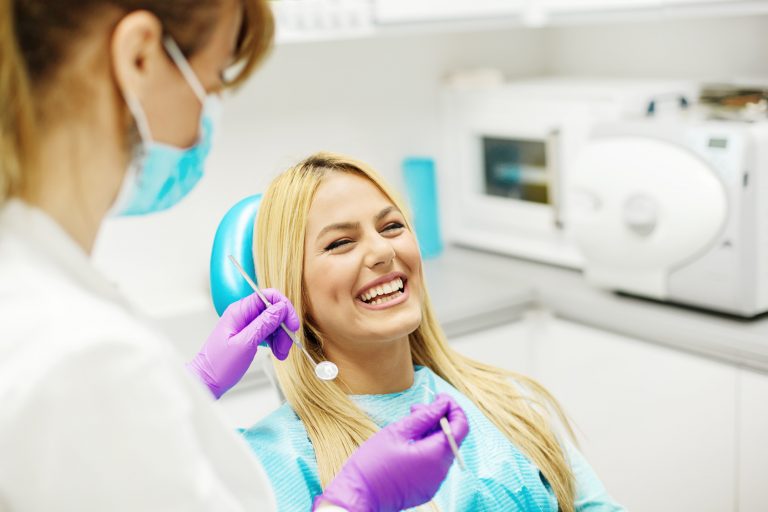 Female dentist and young woman patient in dentist office.