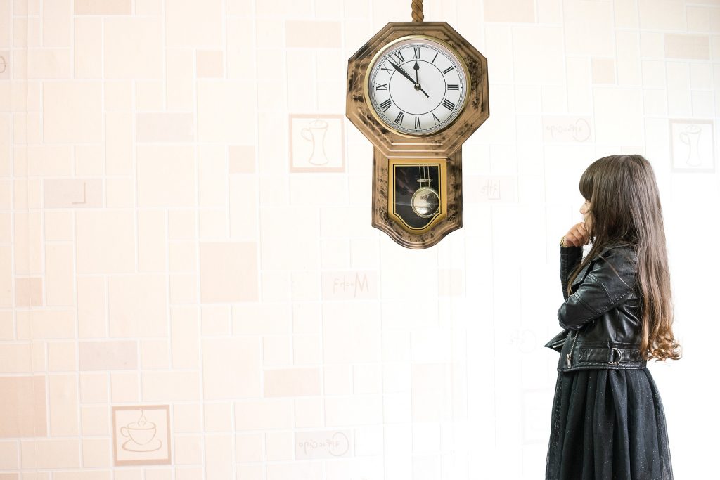woman looking up at a clock