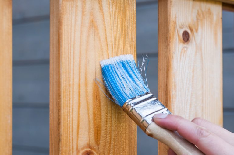 someone varnishing some wooden decking