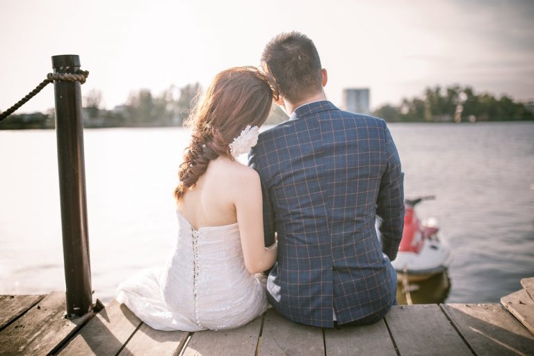 newly weds sat on a pier