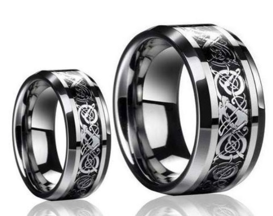 Two Tungsten Carbide Rings with a shiny silver finish, each featuring intricate black Celtic knot designs engraved around the band, are displayed side by side on a white background.