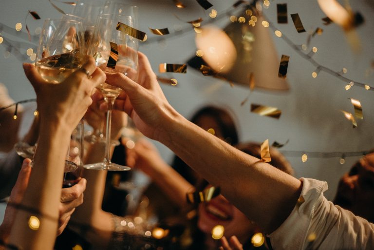 people making a toast with gold confetti falling down from above