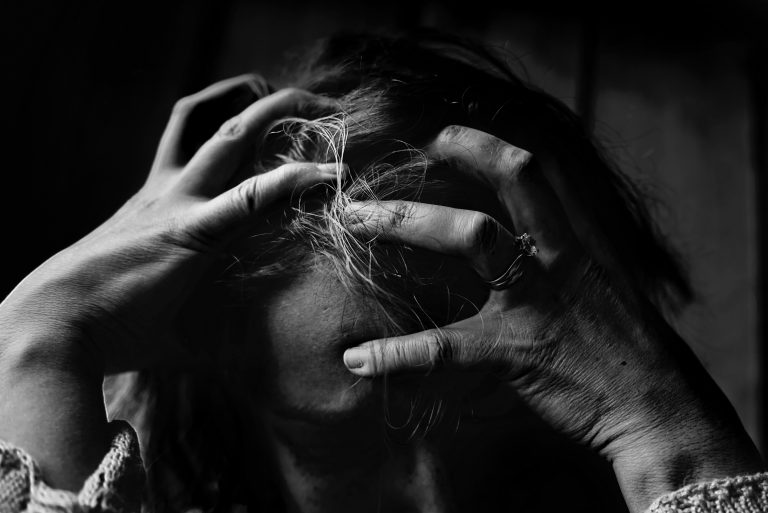 Black and white photograph of a woman with her head in her hands