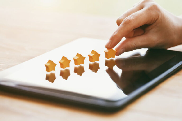 Someone placing 5 plastic stars on top of a tablet