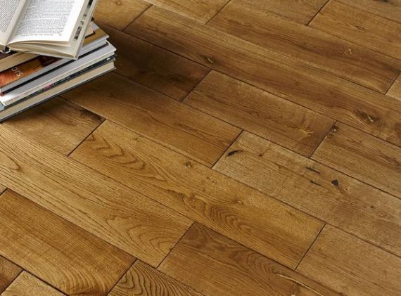 A pile of books sat on solid wood flooring