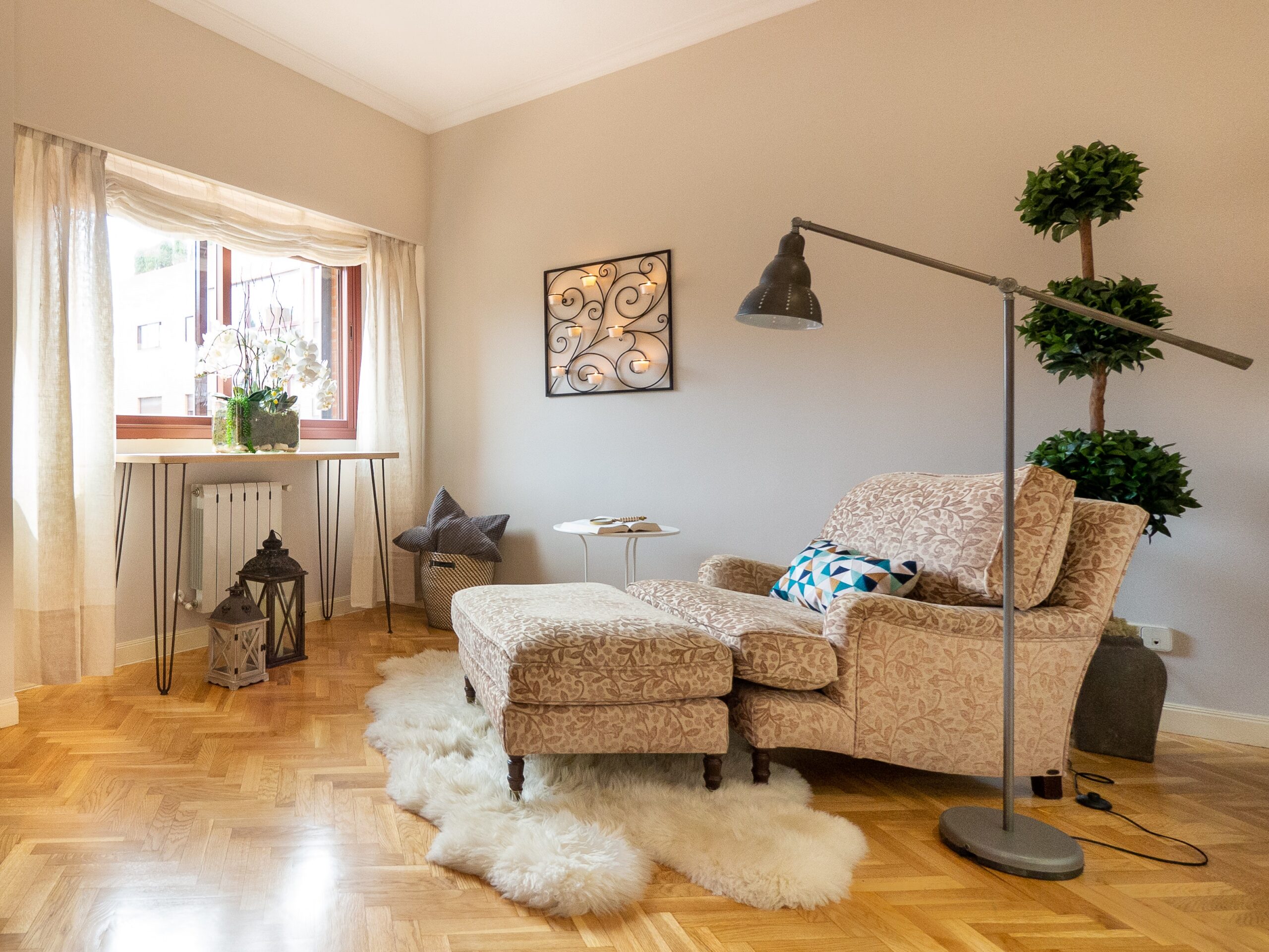 a cream armchair with foot rest sat on a parquet floor