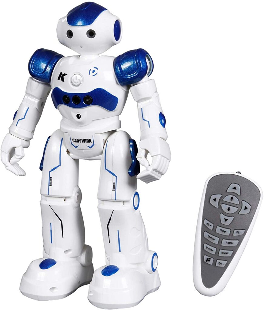 A white and blue humanoid toy robot stands upright next to a grey and white remote control featuring several buttons with arrows and labels—one of the top Christmas gift ideas for fans of remote control toys.