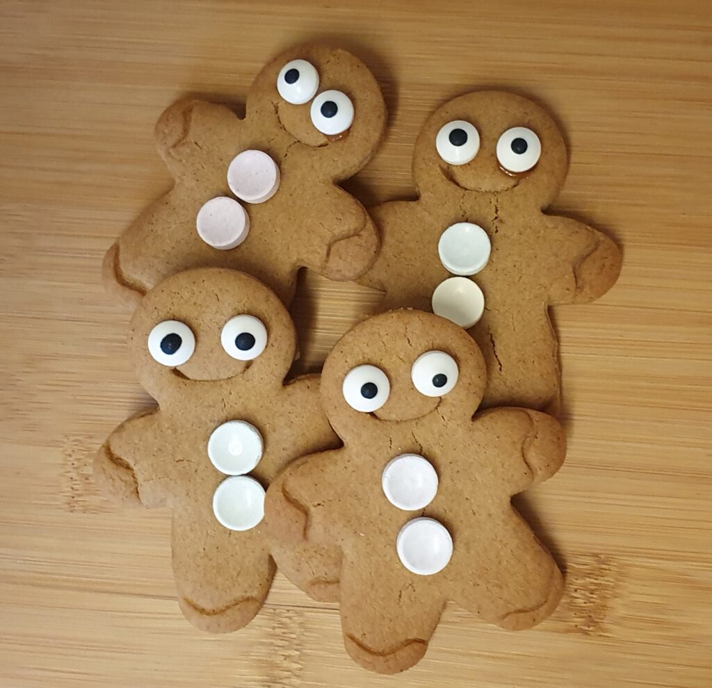 Four homemade gingerbread decorated with Swizzel Fizzer sweets for buttons